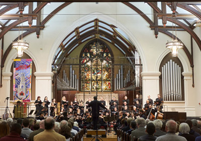 Photo of orchestra performing in a church||Photo of orchestra performing in a church