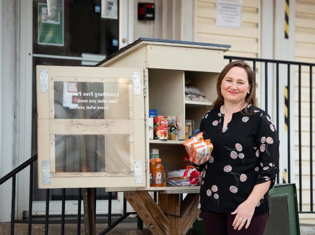Megan Huffman poses in front of a small community food pantry