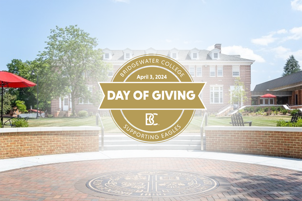 Picture of Rebecca Quad with gold Day of Giving logo in the middle of the photo with a while blurred background